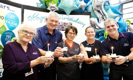 Five Fiona Stanley HOspital staff members each holding a cupcake with a candle on top